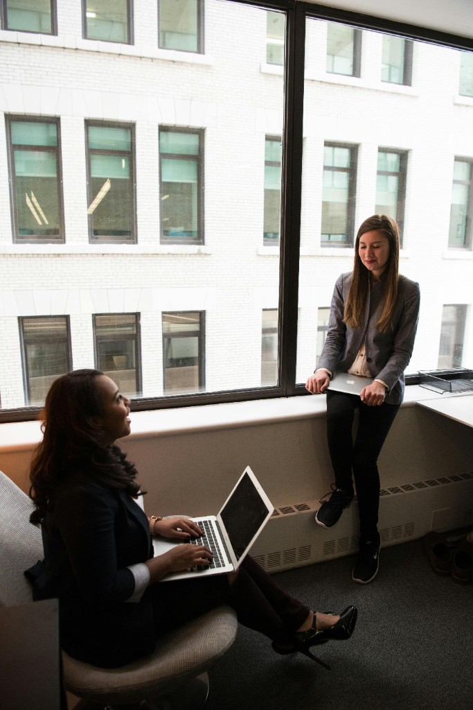 Two women in conversation by an office window